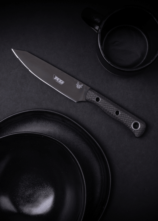 Custom Benchmade Station Knife with a company logo laser-marked on the blade, displayed with black tableware as a premium corporate gift.